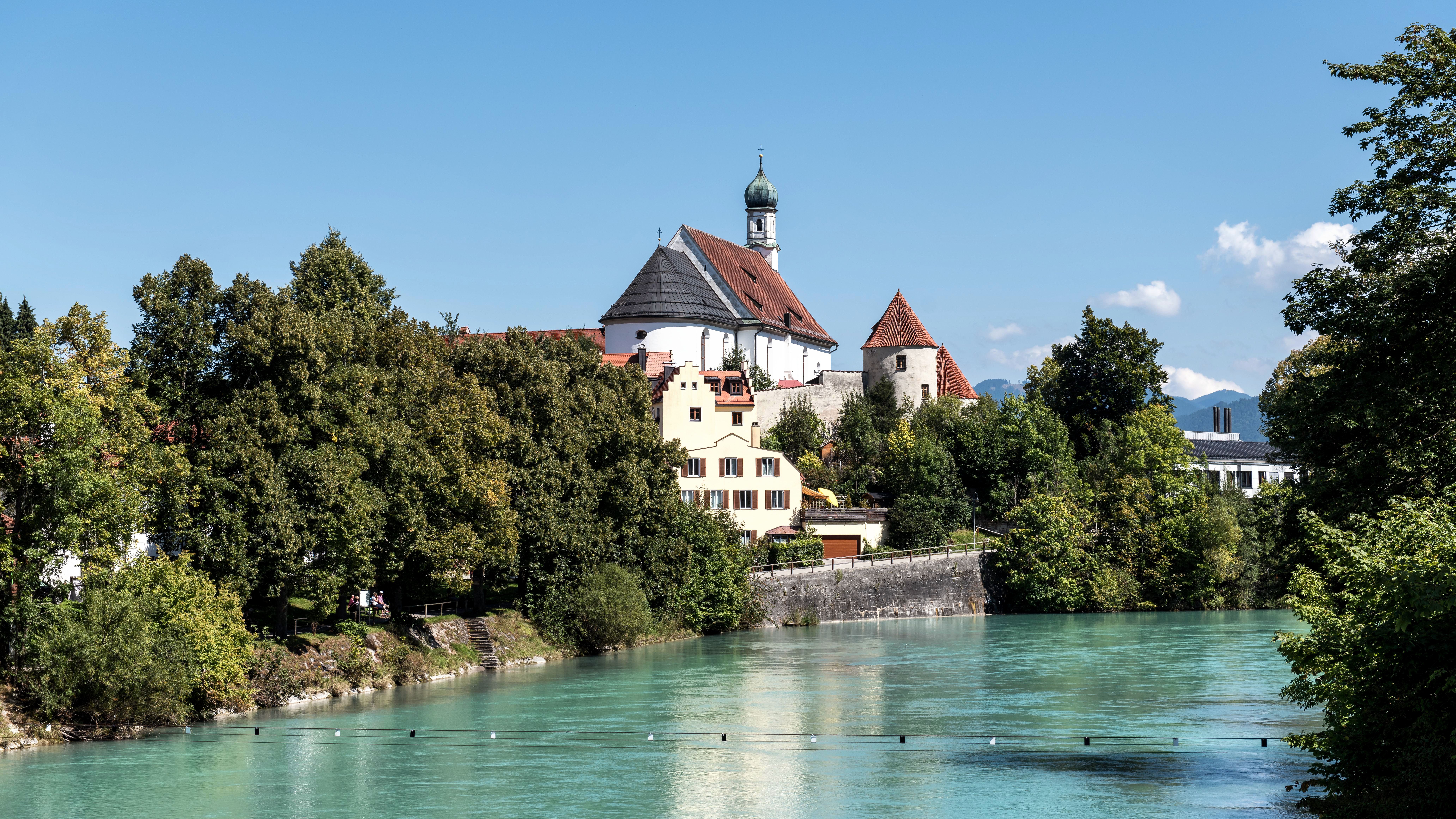 Picturesque town view in Füssen, Germany with a historic church and a river.